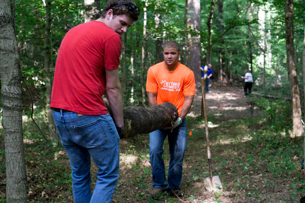 The Dubois County Leadership Academy Team, Trail Blazers, is creating a .27 mile extension to the cross country trail on the Vincennes University Jasper Campus. Members Mark Csernik and Clyde Harper, both Kimball Electronics employees, work to move a log that will line the new route through the woods.