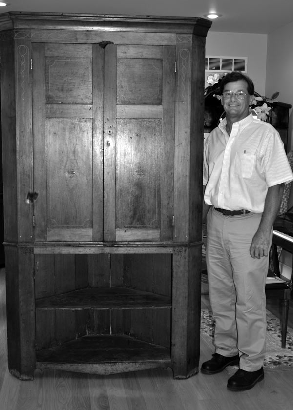 Haaff poses next to the cabinet, still beautiful but showing wear. Note the gnawed spot atop the upper doors. - - Photos by Kathy Tretter 